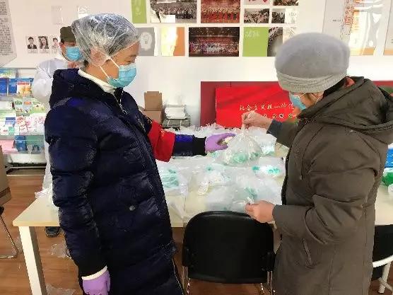 為樓棟分發(fā)口罩，并為包裝袋消毒